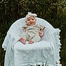 baby, child, outdoor, nature, greenery, grass, chair, blanket, headband, knitted_clothing, smile, portrait, infant, cute, sitting, happy, daylight, forest, young_child, person