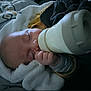 Aleck participe au concours pour gagner de l'argent avec cette photo : baby, bottle, feeding, blanket, sleeping, infant, hand, cozy, soft_lighting, clothing, portrait, closeup, peaceful, indoor, child, face, newborn, resting, cute, warm