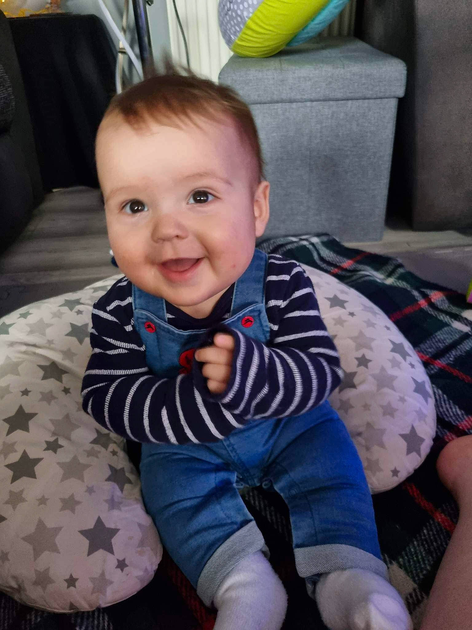 Cameron is registered to the contest to win money with this photo: baby, baby_products, baby_toddler_clothing, chair, cheek, child, comfort, eye, face, happy, head, joy, lap, pattern, person, room, sitting, sleeve, smile, sock