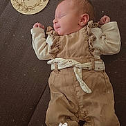 Kassy a rejoint le concours — aidez-le/la à gagner de superbes lots ! newborn, baby, sleeping, infant, brown_clothing, cream_clothing, plush, soft, wooden_plaque, text, portrait, laying_down, peaceful, cute, child, baby_clothes, indoor, closeup, face, hands