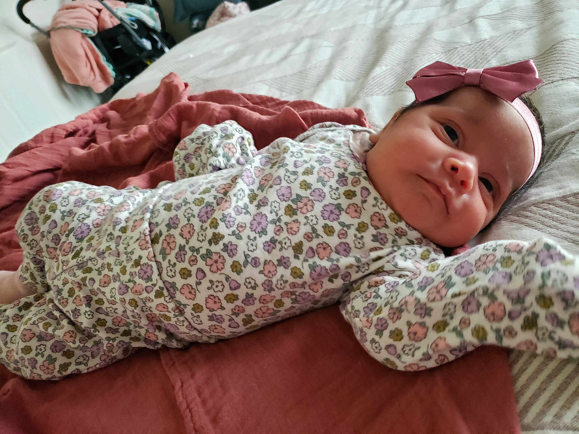 Idalyz is registered to the contest to win money with this photo: baby, infant, bed, blanket, headband, bow, flower_pattern, clothing, sleepwear, person, face, skin, resting, indoors, cute, child, newborn, portrait, soft_fabric, pink