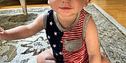 Bentley joined the competition — help win amazing prizes! baby, child, indoor, carpet, rug, sitting, cute, face, eyes, smile, clothing, patterned_rug, floor, furniture, couch, table, armchair, person, skin, hand