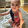 baby, child, indoor, carpet, rug, sitting, cute, face, eyes, smile, clothing, patterned_rug, floor, furniture, couch, table, armchair, person, skin, hand