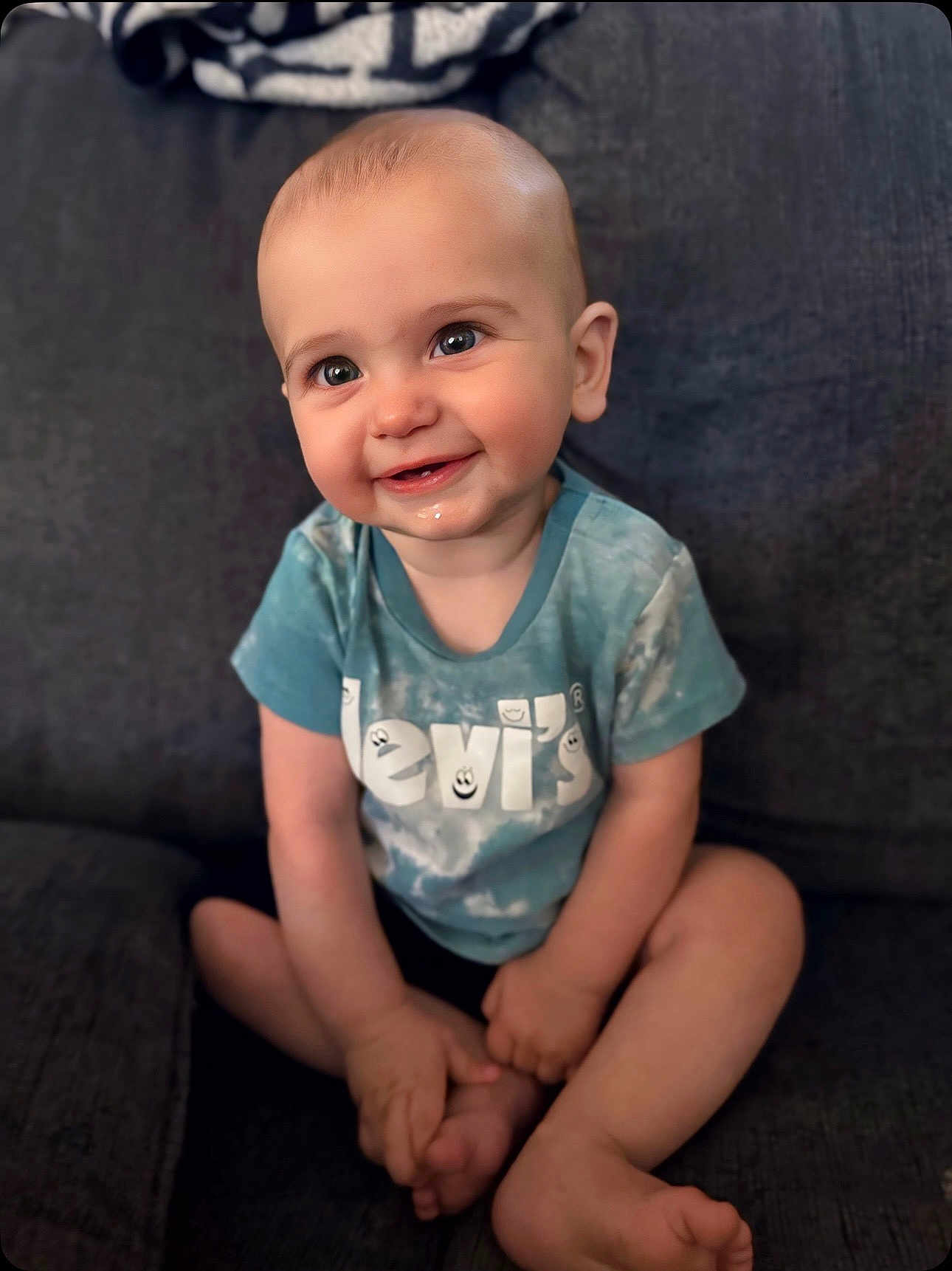 Bentley joined the competition — help win amazing prizes! baby, child, smiling, sitting, cross_legged, tshirt, levis, happy, cute, indoors, couch, person, infant, face, skin, legs, hands, foot, head, expression