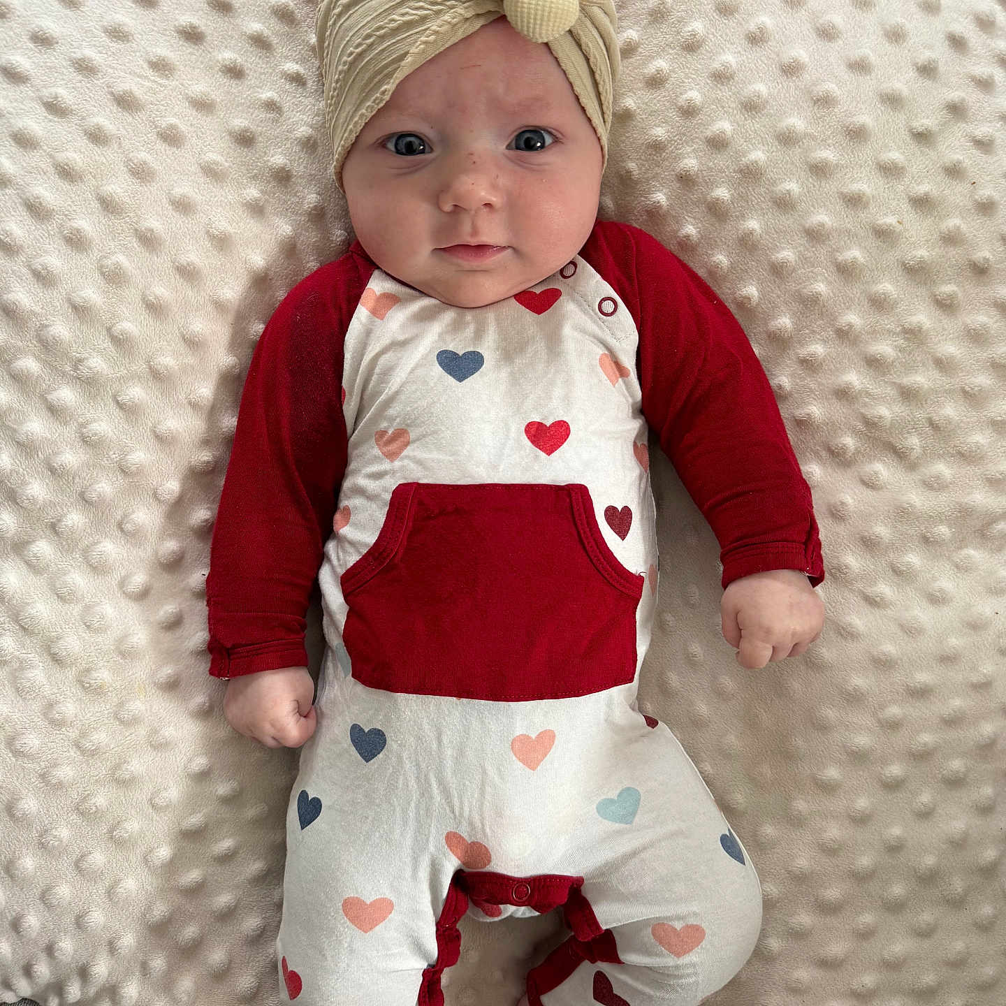 Oaklynn is registered to the contest to win money with this photo: adorable, baby, baby_bedding, blanket, cheeks, cozy, eyes, feet, gaze, hands, headband, heart_pattern, infant, lying_down, newborn, onesie, plush_pillow, portrait, red_sleeves, soft_texture