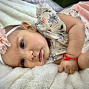 Monserrat is registered to the contest to win money with this photo: baby, infant, headband, flower, blanket, cute, face, skin, hand, clothing, lying_down, portrait, child, adorable, soft, pink, white, closeup, newborn, resting