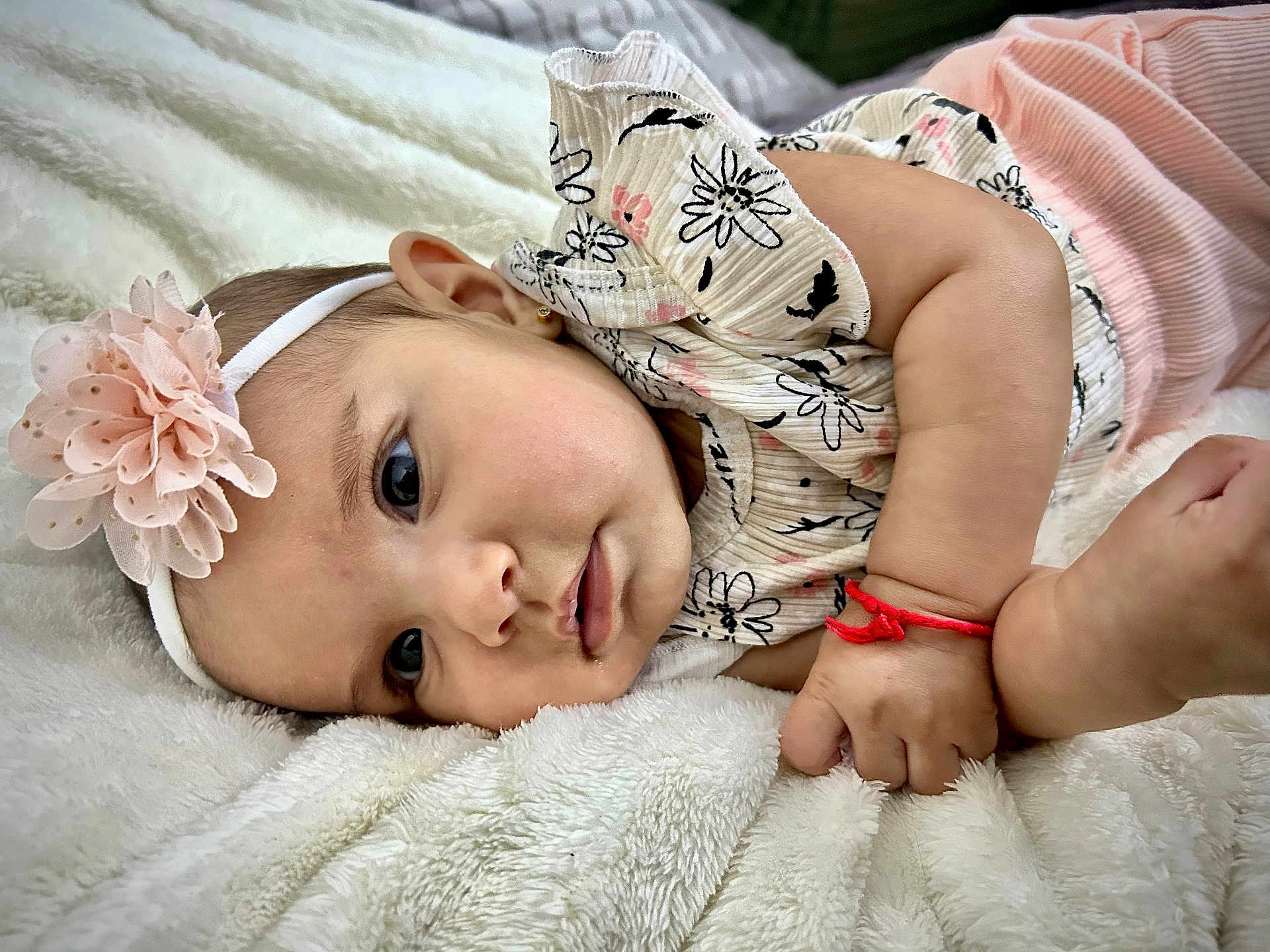 Monserrat is registered to the contest to win money with this photo: baby, infant, headband, flower, blanket, cute, face, skin, hand, clothing, lying_down, portrait, child, adorable, soft, pink, white, closeup, newborn, resting