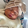 Mia is registered to the contest to win money with this photo: newborn, baby, sleeping, headwrap, bow, knitwear, sweater, face, closed_eyes, infant, cute, cozy, portrait, soft_light, indoor, child, peaceful, skin, closeup, resting