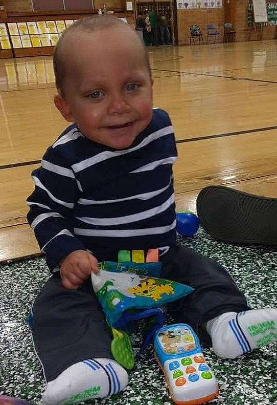 Xavier is registered to the contest to win money with this photo: baby, baby_toddler_clothing, child, flooring, fun, hardwood, holiday, human_leg, joy, lap, leisure, person, play, room, sitting, skin, smile, sock, toddler, wood