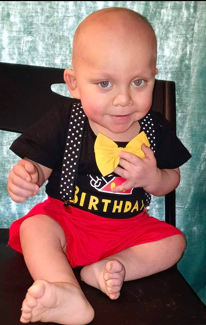 Xavier is registered to the contest to win money with this photo: arm, baby, baby_toddler_clothing, cheek, dress, finger, gesture, hand, happy, human_body, human_leg, iris, joy, knee, neck, person, pink, skin, sleeve, thigh