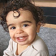 Martin participe au concours pour gagner de l'argent avec cette photo : toddler, child, smiling, curly_hair, indoors, carpet, television, happy, cute, face, person, baby, young_child, casual_clothing, portrait, closeup, bright_eyes, expression, sitting, home