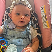 Amara is registered to the contest to win money with this photo: baby, child, headwrap, pacifier, toy, blanket, clothing, seat, infant, cute, portrait, hand, face, expression, indoor, comfort, soft, colorful, play, young