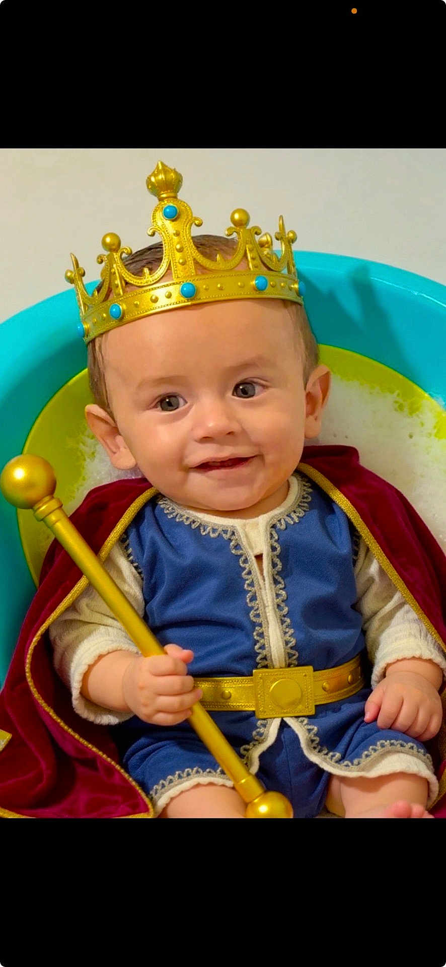 Antonio is registered to the contest to win money with this photo: baby, child, crown, king, costume, scepter, cape, blue_outfit, smiling, bubbles, tub, golden, portrait, happy, indoor, cute, infant, seated, playful, royalty