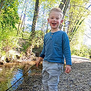 Kenzo participe au concours pour gagner de l'argent avec cette photo : adventure, blue_shirt, boy, casual_clothing, child, creek, daytime, forest, happy, nature, outdoor, pants, play, rocks, shoes, smiling, stick, sunlight, trees, water