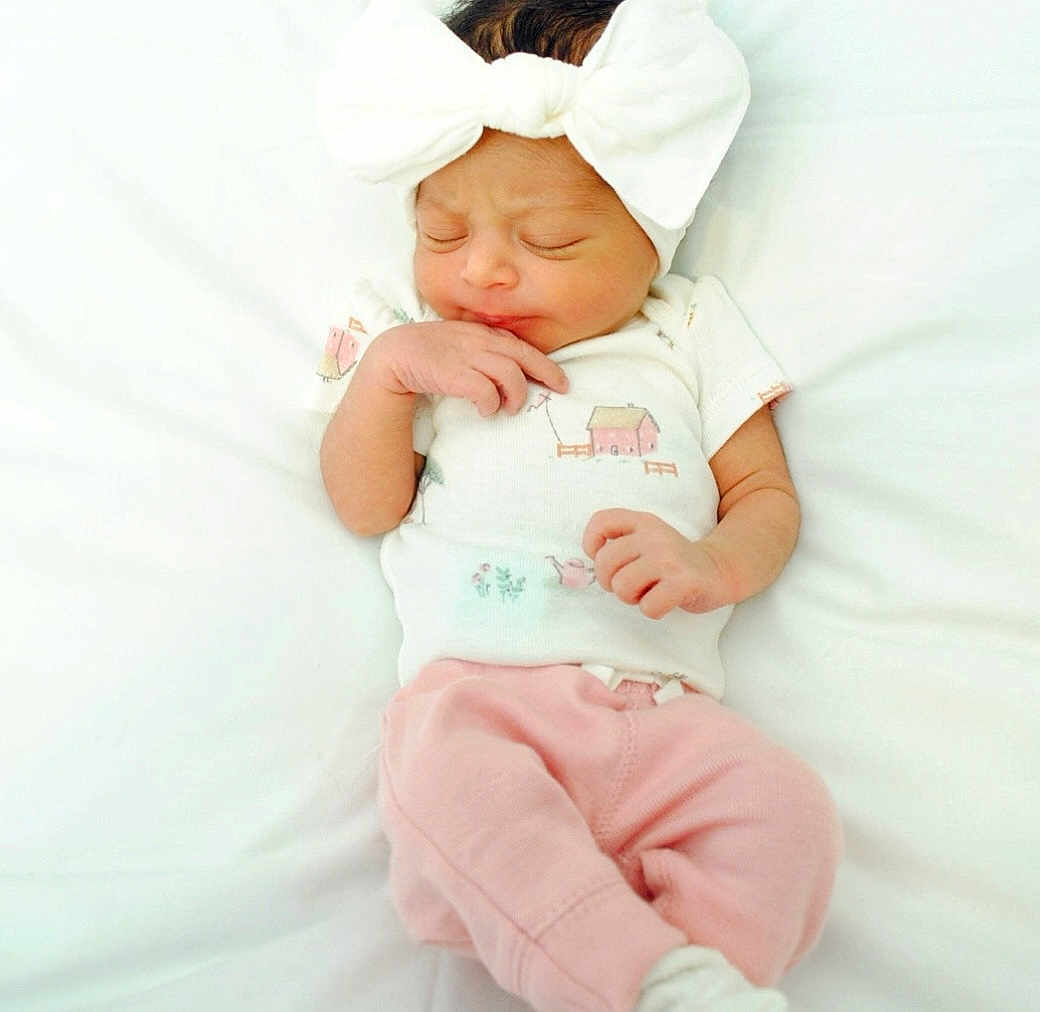 Averie is registered to the contest to win money with this photo: baby, newborn, infant, sleeping, white_bow, pink_pants, white_shirt, cute, peaceful, soft_blanket, lying_down, small_hands, closed_eyes, indoors, portrait, child, adorable, sleep, baby_clothes, headwear