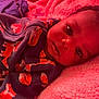 baby, infant, face, eyes, clothing, sleeper, fox_pattern, blanket, pink, soft_texture, lying_down, closeup, portrait, curious, indoors, child, cute, warm_light, cozy, sleepwear