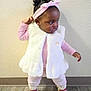 Sariah is registered to the contest to win money with this photo: toddler, child, girl, pink_clothing, headband, bow, white_vest, standing, pose, indoor, flooring, wall, curly_hair, earrings, footwear, boots, expression, looking_away, cute, fashion