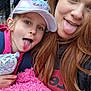 Anna is registered to the contest to win money with this photo: child, young_person, selfie, tongue_out, cap, pink, sequin_toy, blanket, closeup, portrait, smiling, playful, hair, eyes, face, female, casual_clothing, backpack, stroller, candid
