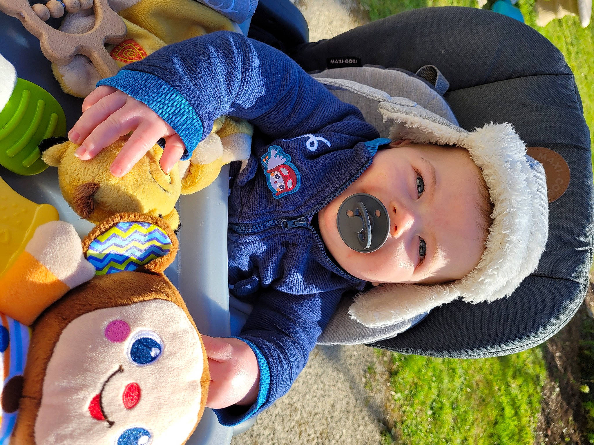 Lino a rejoint le concours — aidez-le/la à gagner de superbes lots ! baby, baby_toddler_clothing, child, fun, grass, happy, hat, headwear, leisure, person, plant, play, recreation, sitting, smile, stuffed_toy, toddler, toy, tree, water_bottle