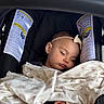 Kaila joined the competition — help win amazing prizes! baby, sleeping, car_seat, blanket, headband, infant, child, cute, peaceful, safety_warning, face, clothing, resting, indoors, soft_light, portrait, young_child, blanket_pattern, toy, hand