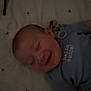 Oliver joined the competition — help win amazing prizes! baby, infant, smiling, child, blue_shirt, text_on_clothing, lying_down, blanket, pattern, happy, face, head, cute, indoors, soft_lighting, young_child, person, sleepwear, toddler, expression
