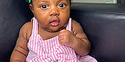 Chimamanda joined the competition — help win amazing prizes! baby, child, infant, dress, pink_stripes, bow, hair_beads, colorful, curly_hair, face, eyes, hand, sitting, chair, leather, indoor, portrait, cute, expression, skin