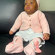 Chimamanda joined the competition — help win amazing prizes! baby, child, infant, pink_clothing, headband, bunny_socks, sitting, couch, black_leather, curious_expression, wide_eyes, soft_lighting, indoors, knitted_sweater, white_shorts, cute, portrait, small_hands, childrens_fashion, footwear