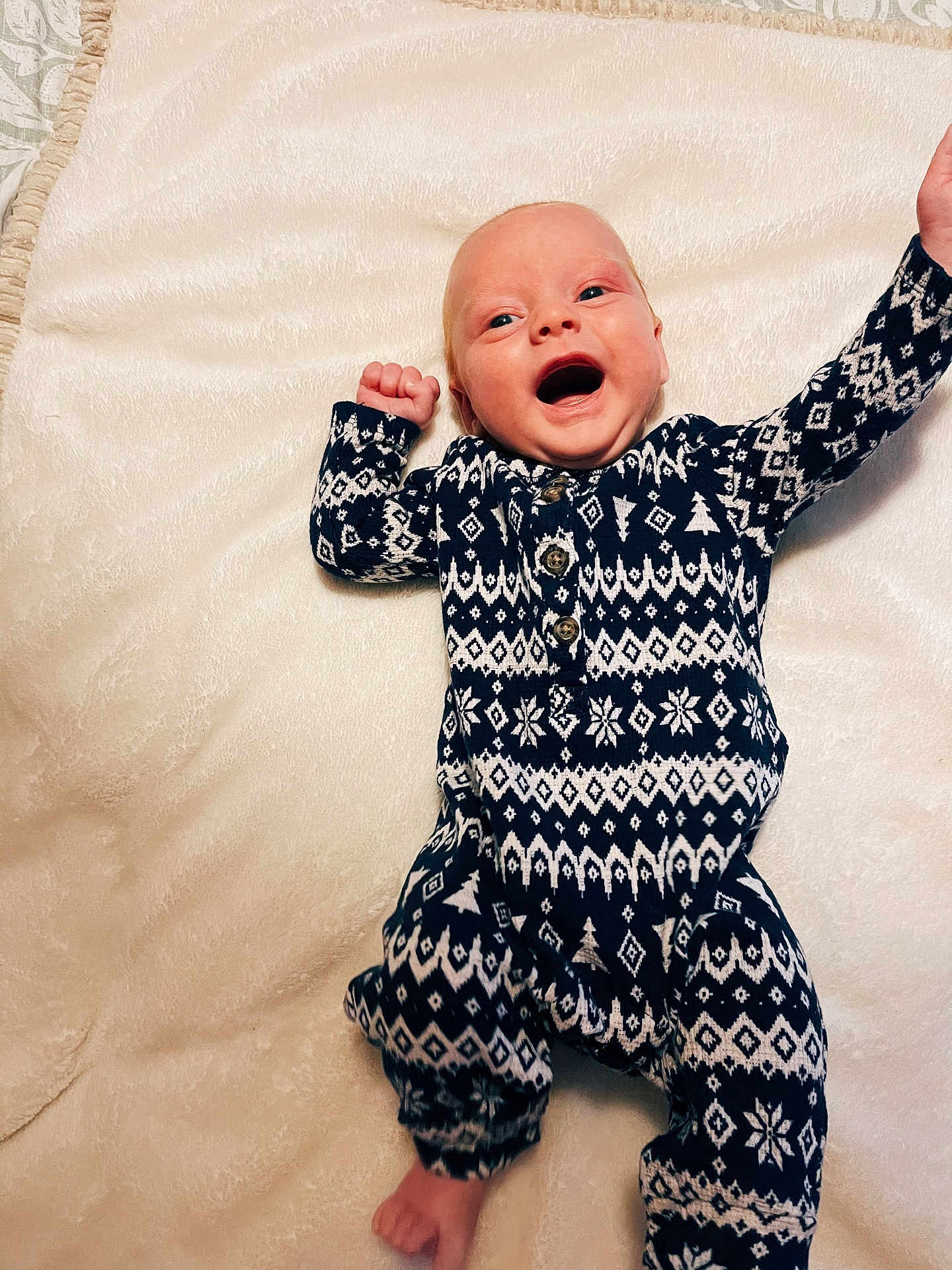 Weston is registered to the contest to win money with this photo: baby, infant, smiling, patterned_clothing, onesie, blanket, happy, lying_down, raised_arms, cute, cozy, indoor, portrait, child, newborn, soft_texture, warm, comfort, face, expression