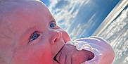Léna participe au concours pour gagner de l'argent avec cette photo : baby, blue_eyes, bright, child, closeup, clouds, cute, expression, face, hand, happy, infant, nature, outdoor, portrait, rosy_cheeks, sky, sunlight, water, white_clothing