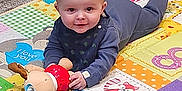 Oakley is registered to the contest to win money with this photo: baby, babycrawling, clothing, crawling, face, footwear, happy, head, homedecor, indoors, mat, pants, person, photography, portrait, quilt, shoe, sitting, text, toy