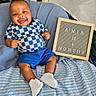 A'Mir joined the competition — help win amazing prizes! baby, infant, smiling, blue_shorts, checkered_shirt, white_shoes, letter_board, blanket, milestone, happy, sitting, indoors, cute, child, portrait, young_baby, clothing, feet, face, joyful