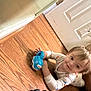 Baylen is registered to the contest to win money with this photo: baby, black_sandal, blue_toy_car, casual, child, door, floor, footwear, happy, home, indoor, light_clothing, patterned_clothing, person, play, smiling, toddler, toy, wooden_floor, young_child