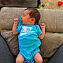 Kohen joined the competition — help win amazing prizes! baby, newborn, pacifier, blue_onesie, nike_logo, socks, sleeping, couch, carpet, toys, infant, person, clothing, indoor, legs, relaxing, comfort, child, home, soft_furniture