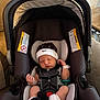 Kohen is registered to the contest to win money with this photo: baby, newborn, car_seat, infant, hat, socks, sleeping, straps, safety_buckle, hospital_id_band, pacifier, black_and_white, indoor, couch, blanket, child, person, seat, headwear, relaxing