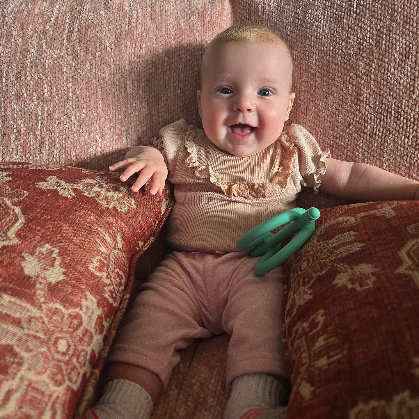 Vanessa joined the competition — help win amazing prizes! baby, infant, smiling, couch, pink, cushions, toy, teething_toy, happy, indoor, child, portrait, cozy, clothing, socks, furniture, home, cute, person, seated