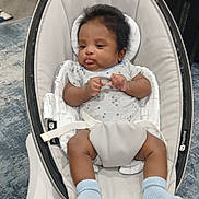 Myles joined the competition — help win amazing prizes! 4moms, baby, baby_rocker, blue_socks, carpet, child, cute, expression, floor, furniture, home, indoor, infant, newborn, onesie, person, portrait, relaxing, safety_strap, seat