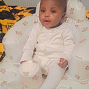 Elizabeth is registered to the contest to win money with this photo: baby, child, infant, white_clothing, baby_chair, teddy_bear_pattern, container, indoor, blanket, cushion, cute, portrait, seated, young_child, comfort, home, furniture, person, soft, adorable