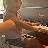 toddler, child, piano, instrument, hands, window, person, indoor, furniture, music, playing, curious, home, light, face, clothing, shorts, sleeveless_shirt, adult, lap