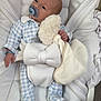 baby, infant, pacifier, onesie, blanket, stuffed_toy, bassinet, quilted, white, blue, clothing, sleepwear, hand, face, head, person, indoor, resting, soft_toy, comfort