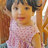 Aairah is registered to the contest to win money with this photo: baby, chair, child, closeup, clothing, curious, cute, eyes, face, hair, happy, indoors, person, pink_dress, polka_dot, portrait, sitting, smiling, toddler, young_child