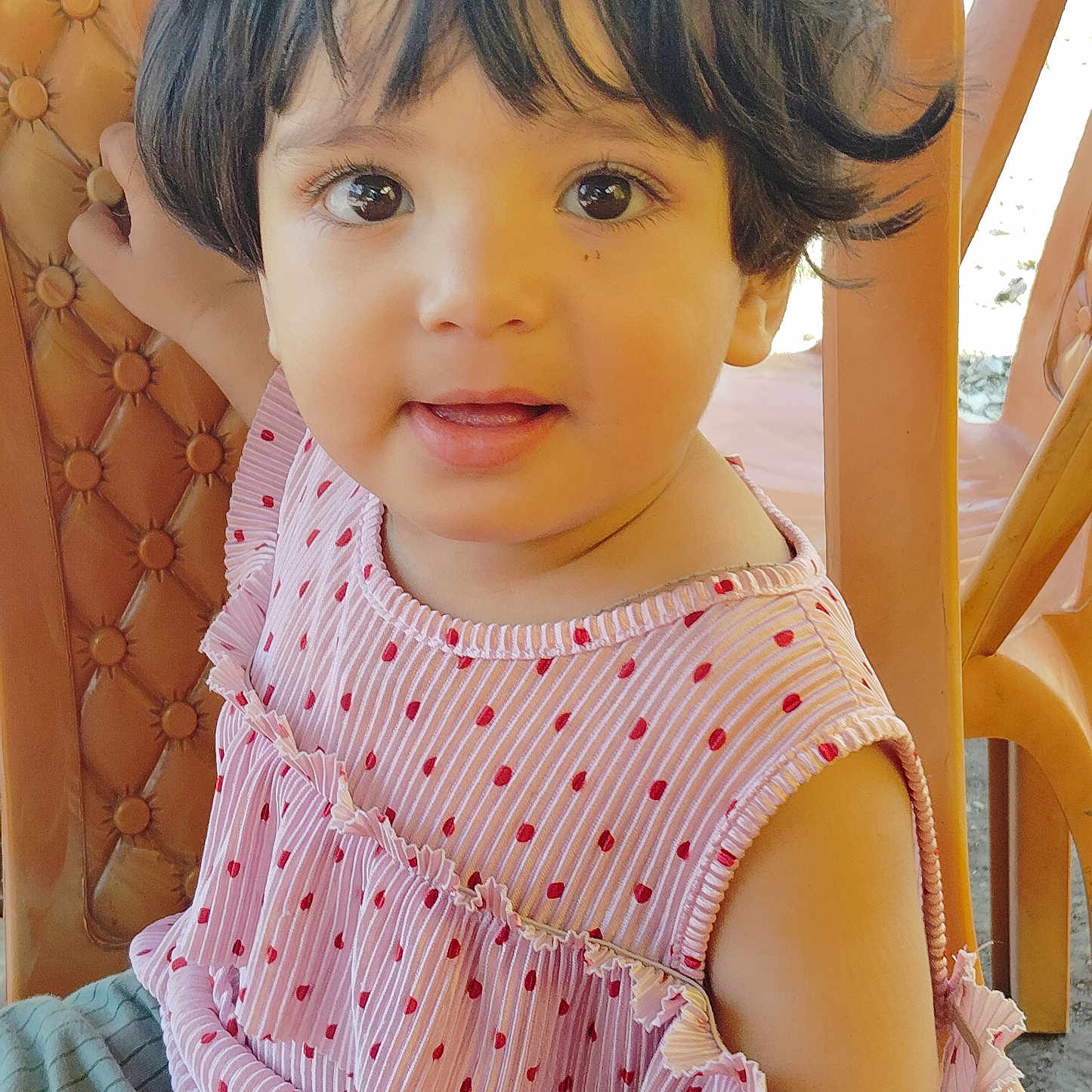 Aairah is registered to the contest to win money with this photo: baby, chair, child, closeup, clothing, curious, cute, eyes, face, hair, happy, indoors, person, pink_dress, polka_dot, portrait, sitting, smiling, toddler, young_child