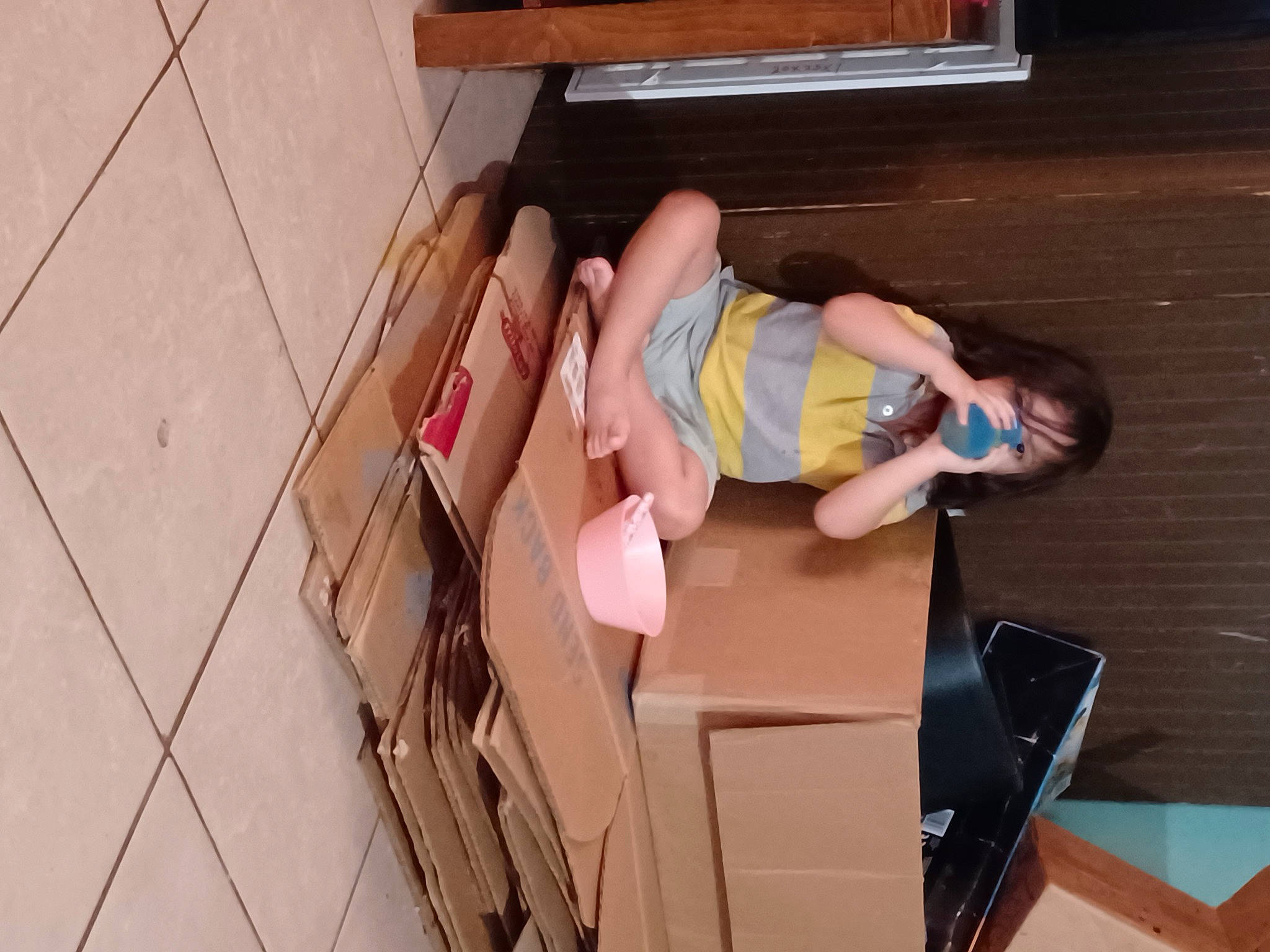 Leonel joined the competition — help win amazing prizes! box, cardboard, carton, child, floor, flooring, fun, hardwood, human_leg, knee, leg, leisure, package_delivery, person, room, sandal, shipping_box, shorts, sitting, thigh