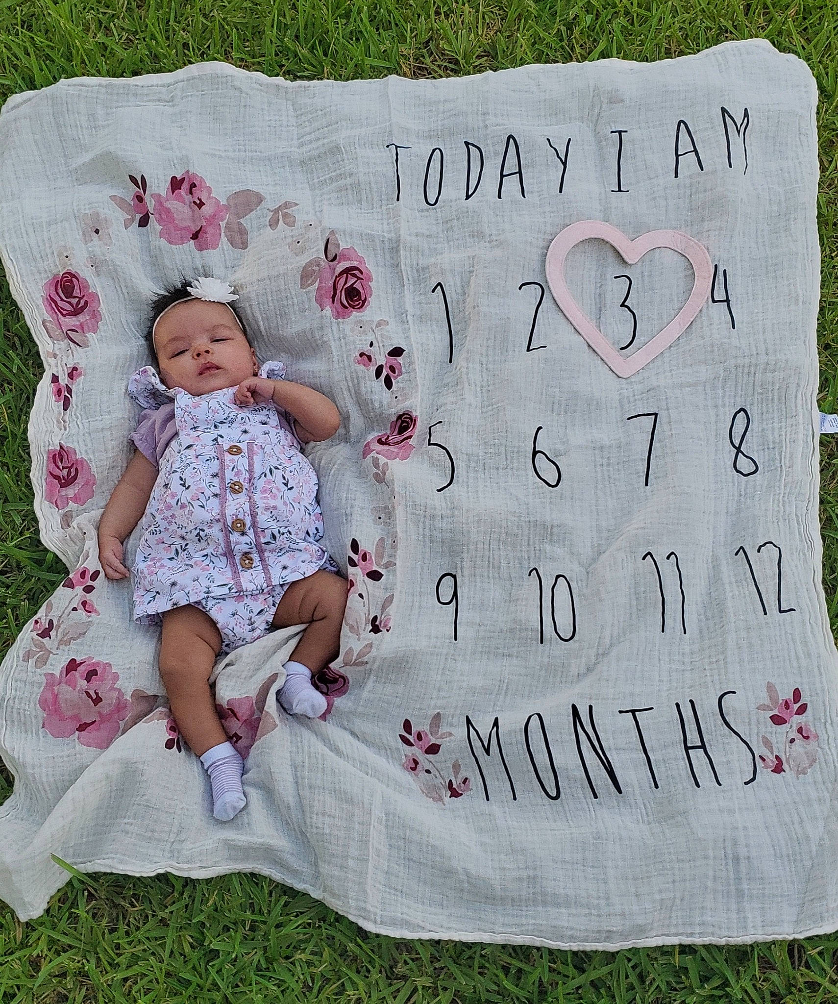 Leilani is registered to the contest to win money with this photo: baby, baby_toddler_clothing, facial_expression, font, grass, hand, handwriting, happy, linens, magenta, mammal, pattern, person, pink, plant, product, rectangle, sleeve, summer, t_shirt