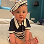 baby, child, sailor_outfit, hat, bed, indoor, cute, portrait, infant, clothing, hands, feet, skin, face, eyes, expression, sitting, soft_light, home, curious