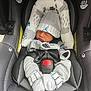 newborn, baby, car_seat, hat, clothing, sleeping, infant, seat_belt, safety, fabric, cushion, pattern, grey, small_hands, cute, resting, indoors, comfort, child, bundle