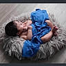 Ashton is registered to the contest to win money with this photo: baby, child, blue_cloth, cushion, floor, infant, newborn, portrait, resting, soft_texture, toddler, wrapped, young_child, indoor, cute, sleepy, relaxed, skin, hair, small