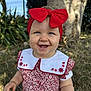 baby, child, smile, red_bow, headband, dress, floral_pattern, outdoor, grass, tree, sunlight, blue_eyes, cute, happy, portrait, nature, embroidery, sitting, toddler, person