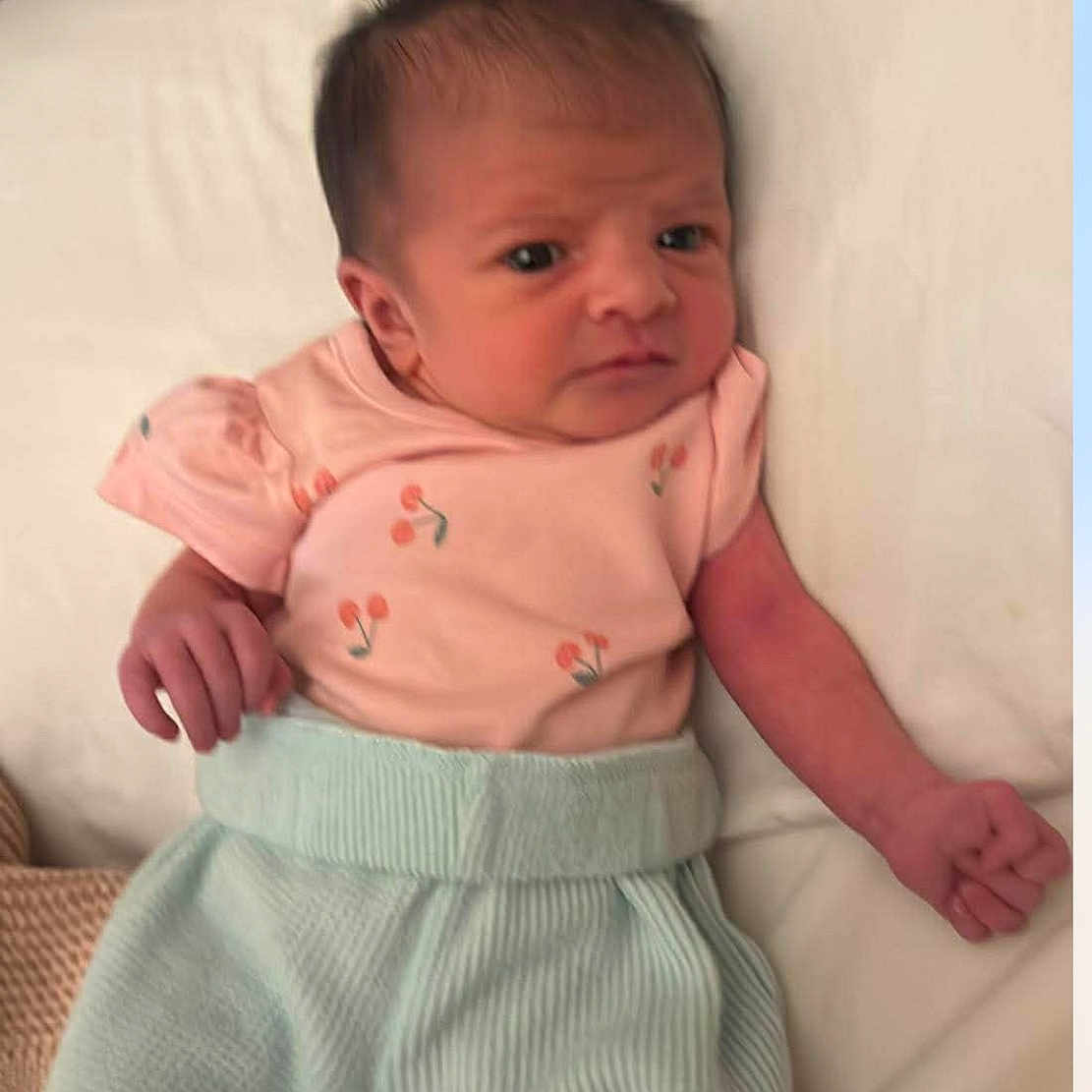 Story is registered to the contest to win money with this photo: baby, bed, blanket, blue_pants, child, clothing, cute, expression, face, hair, hand, indoors, infant, lying_down, newborn, person, pink_shirt, portrait, skin, soft