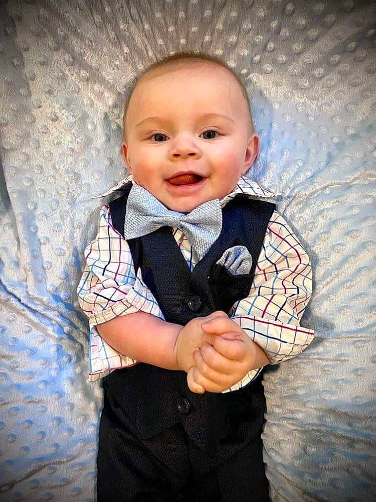 Otis is registered to the contest to win money with this photo: arm, baby, baby_toddler_clothing, bow_tie, collar, dress, dress_shirt, flash_photography, formal_wear, gesture, happy, outerwear, pattern, person, plaid, skin, sleeve, smile, suit, tie