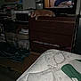 bed, blanket, books, box, cat, clutter, dresser, electronics, flash, furniture, indoor, man, microwave, orange_cat, person, reflection, resting, room, storage, television
